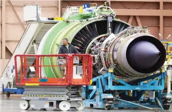  ??  ?? A Boeing employee drives a lift near a GE engine for a Boeing 777 airliner at the Boeing Factory in Everett, Washington recently. (Photo by Stephen Brashear/Getty Images)