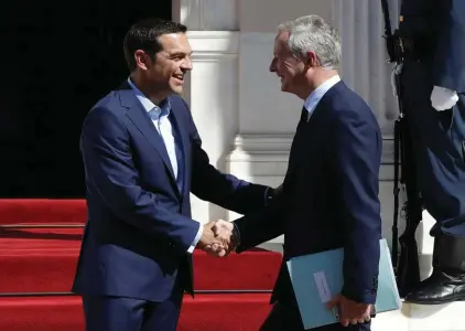  ??  ?? Greek Prime Minister Alexis Tsipras, left, welcomes French Economy Minister Bruno Le Maire at Maximos Mansion in Athens on Thursday