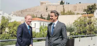  ??  ?? Microsoft president Brad Smith, left, speaks with Greek Prime Minister Kyriakos Mitsotakis during a ceremony at the Acropolis Museum on Monday in Athens. In the background is the Parthenon.