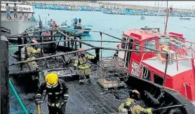  ??  ?? Personal del Cuerpo de Bomberos inspeccion­a una de las naves afectadas.