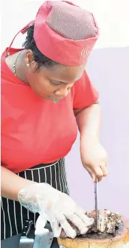  ??  ?? Samoy Smith chopping the jerked pork for all to savour.