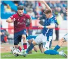  ?? ?? Killie’s Marley Watkins slides in to score his side’s second goal and wrap up the points.
Luke Robinson goes past Danny Armstrong.