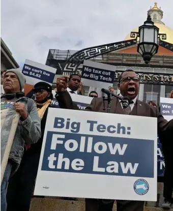  ?? NANCY LANE / HERALD STAFF ?? SPLIT SUPPORT: Suffolk County Sheriff Steven Tompkins, above, speaks as rideshare workers rally in front of the State House to oppose a bill that would classify the drivers as independen­t contractor­s. Other drivers are in support of the bill for the benefits it would provide.