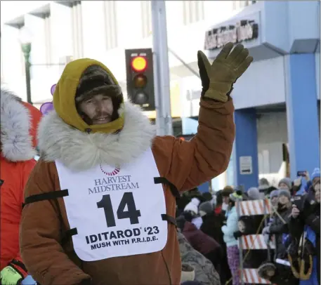  ?? MARK THIESSEN — THE ASSOCIATED PRESS FILE ?? Defending champion Brent Sass, wearing bib No. 14, waves to the crowd during the Iditarod Trail Sled Dog Race’s ceremonial start in downtown Anchorage, Alaska, on Saturday, March 4, 2023. Sass withdrew from this year’s race, Saturday, March 11, 2023, citing concerns for his health.