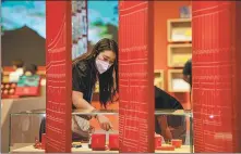  ?? HU CHAO / XINHUA ?? A visitor browses cultural products at the exhibition booth of the Palace Museum during the China Internatio­nal Travel Mart 2022 in July in Kunming, Yunnan province.