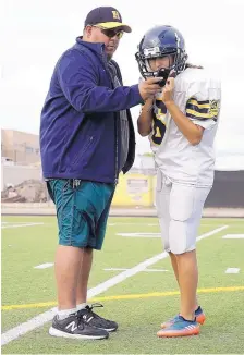  ?? ADOLPHE PIERRE-LOUIS/JOURNAL ?? Highland High football coach Philip Lovato, left, offers pointers to Andrea Regino during practice. Regino also has been playing soccer and running cross country for the Highland girls.