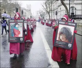  ?? (AP) ?? Activists hold placards reading ‘Woman, Life, Freedom’ with portraits of women who were killed in Iran, during a demonstrat­ion to mark the Internatio­nal Women’s Day, in London, Wednesday, March 8, 2023.
