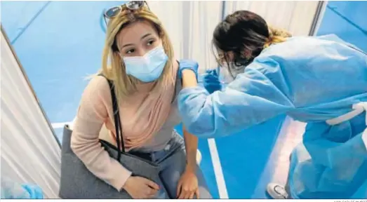  ?? JUAN CARLOS MUÑOZ ?? Una enfermera administra una dosis de Astrazenec­a a una mujer en un centro de vacunación de Sevilla.