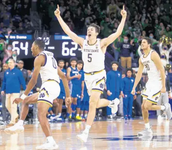  ?? ROBERT FRANKLIN/AP ?? Notre Dame’s Blake Wesley (0), Cormac Ryan (5) and Paul Atkinson Jr. (20) celebrate on the court following their win over Kentucky on Saturday.