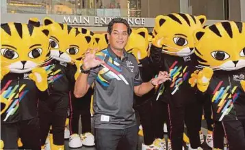  ?? PIC BY MAHZIR MAT ISA ?? Sports Minister Khairy Jamaluddin with the RIMAU mascots at the launch of the official theme song ‘Bangkit Bersama’ in Kuala Lumpur yesterday.