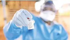  ??  ?? File photo shows a Congolese health worker holding the Ebola vaccine outside the house of a victim who died from Ebola in the village of Mangina in North Kivu province of the Democratic Republic of Congo. — Reuters photo