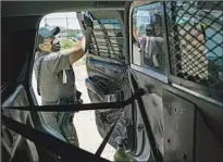  ??  ?? OFFICER Carolyn Tallsalt disinfects the back of her police vehicle after taking a man to jail on the Navajo reservatio­n.