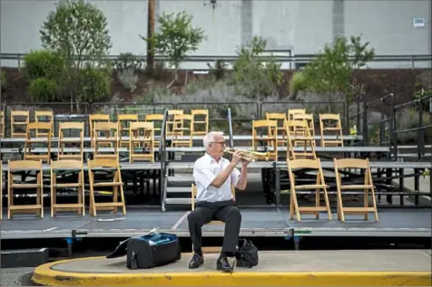  ?? Alexandra Wimley/ Post- Gazette ?? Pittsburgh Symphony Orchestra trumpeter Charles Lirette warms up during a soundcheck for the Pittsburgh Ballet Theatre's Open Air Concert Series on Sunday at the ballet’s mobile stage in the Strip District. Several ad hoc performanc­es of classical music were held recently, but Sunday’s was the first official performanc­e of symphony orchestra since the pandemic began.