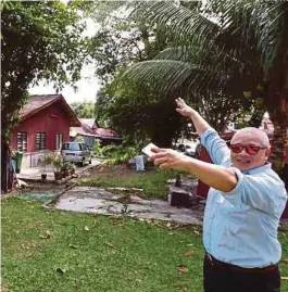  ?? [FOTO MIKAIL ONG/BH] ?? Lee menunjukka­n lot tanah yang didakwa diambil alih CMI di Jalan Pierce, Lengkok Burmah, Pulau Pinang, semalam.