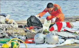  ?? AP PHOTO ?? A member of the Indonesian Search and Rescue Agency inspects debris believed to be from Lion Air passenger jet that crashed off Java Island in Jakarta on Monday.