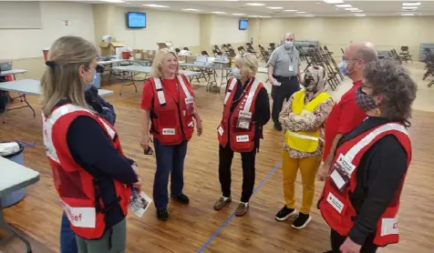  ?? Paula Bauerle photos ?? Paula Bauerle, third from the left, chats with other disaster volunteers with the American Red Cross Greater Pennsylvan­ia Region at the Castle Shannon Volunteer Fire Department COVID-19 vaccinatio­n site.
