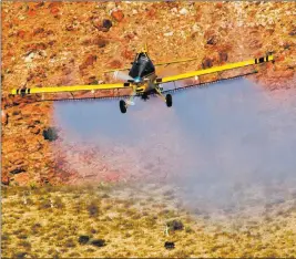 ??  ?? Bureau of Land Management An airplane sprays herbicide on public land southwest of the Las Vegas Valley on Oct. 3 as part of an effort to halt the spread of invasive grasses in an area burned by the Goodspring­s Fire in 2005.