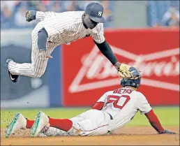  ?? N.Y. Post: Charles Wenzelberg ?? HEAD OVER HEELS: Didi Gregorius flies over Boston’s Mookie Betts before taking a cleat to the chest in the first inning Thursday. Gregorius shook it off, and went 2-for-4 in the Yanks’ 9-1 win.