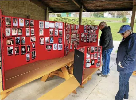  ?? NICHOLAS BUONANNO — NBUONANNO@TROYRECORD.COM ?? People look at some photos of people who have been killed from domestic violence or other crimes during a memory walk in East Greenbush on Thursday. From left are Pete Benko and Beverly Helmes.