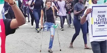  ?? Photo Credit: Sahara Reporters ?? Jane with crutches joins other #ENDSARS protesters in Abuja and received over N4 million as donation, after a medical doctor called for donations from other members of the group for the purchase of prosthesis to enable her walk properly