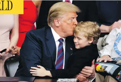  ?? EVAN VUCCI / THE ASSOCIATED PRESS ?? President Donald Trump kisses Jordan McLinn, a Duchenne Muscular Dystrophy patient, after signing the “Right to Try” act in the South Court Auditorium on the White House campus in Washington on Wednesday.