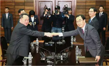  ??  ?? Working together: Cho (right) shaking hands with his North Korean counterpar­t Ri during their meeting in the border village of Panmunjom. — AFP