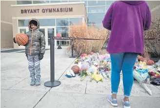  ?? Johannes Eisele, AFP/Getty Images ?? People pay their respects Monday outside Bryant Gymnasium at Lower Merion (Pa.) High School, which basketball legend Kobe Bryant attended.