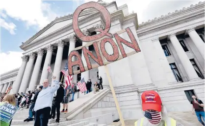  ?? THOMPSON/AP ELAINE ?? A protester with a QAnon sign protests Washington state’s stay-home order to slow the COVID-19 outbreak last year.