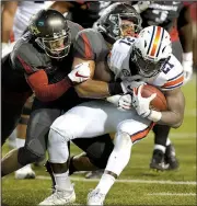  ?? NWA Democrat-Gazette/ANDY SHUPE ?? Arkansas linebacker Dwayne Eugene (center) helps bring down Auburn running back Kerryon Johnson (21) during the Razorbacks’ 52-20 loss to the Tigers Saturday night.