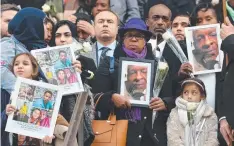  ??  ?? Mourners hold portraits of victims at the Grenfell Tower National Memorial service at St Paul's cathedral.