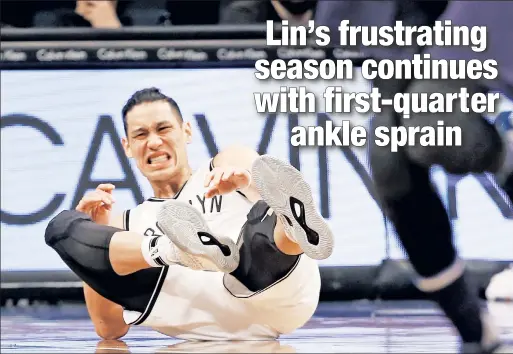  ?? AP ?? LANDING FEAR: Nets point guard Jeremy Lin winces in pain as he falls to the floor with an ankle sprain during the first quarter of a loss to the Mavericks at Barclays Center on Sunday afternoon.