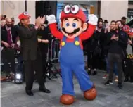  ?? DAVE KOTINSKY/GETTY IMAGES FOR NINTENDO OF AMERICA ?? Reggie Fils-Aime, president and COO of Nintendo of America, joins Mario to welcome guests to the Super Mario Odyssey launch in New York.