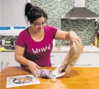  ?? DARRYL DYCK/THE CANADIAN PRESS ?? Jayne Zhou unwraps a HelloFresh Cajun fish tacos meal kit in her Vancouver home.