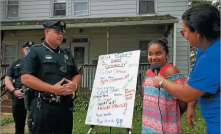  ?? FRAN MAYE – DIGITAL FIRST MEDIA ?? Alicia Jones, CEO of La Comunida Hispana, talks to a Kennett Square girl about the positive interactio­n she has with police officers, as Kennett Square Ptl. Todd looks on.