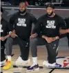  ?? PHOTO: REUTERS ?? Unified message . . . LeBron James (left) and Anthony Davis of the Los Angeles Lakers kneel with their teammates in support of the Black Lives Matter movement before their game against the LA Clippers in Lake Buena Vista, Florida yesterday.