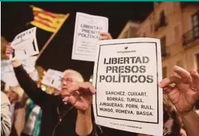  ?? REUTERS PIC ?? People holding up placards reading ‘free political prisoners’ during a gathering in support of dismissed Catalan cabinet members in Tarragona, Catalonia, on Thursday.