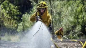  ?? PAUL KITAGAKI JR. — THE SACRAMENTO BEE VIA AP ?? Fire crews battle the Pawnee Fire on Cache Creek Road on Monday in Spring Valley.