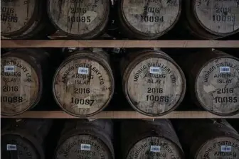  ??  ?? Barrels in the warehouse of Ardbeg Distillery on the island of Islay. In places, the smell of peat from barley stored in Victorian times still lingered in the air at the distillery site, which opened in 1815.