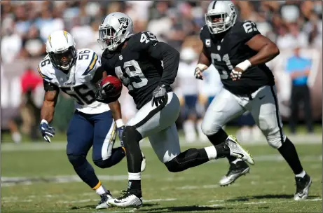  ?? JOSIE LEPE/TRIBUNE NEWS SERVICE ?? Oakland Raiders' Jamize Olawale (49) runs with the ball against the San Diego Chargers' Korey Toomer (56) on Oct. 9 in Oakland.