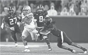  ?? KYLE ROBERTSON/COLUMBUS DISPATCH ?? Ohio State Buckeyes running back Treveyon Henderson (32) gets past Minnesota Golden Gophers defensive back Michael Dixon (11) and scores a touchdown after a catch during the fourth quarter on Thursday.