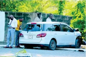  ?? ERROL CROSBY ?? Police search the vehicle in which three gunmen were using in Portmore yesterday, allegedly to carry out a murder in Waterford.