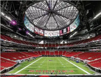  ?? JOHN SPINK / JSPINK@AJC.COM ?? Media members get a glimpse of the field inside the new $1.5 billion Mercedes-Benz Stadium, which will open this month as home of the Falcons, Atlanta United and college football games.