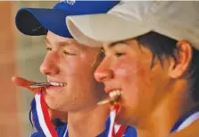  ?? STAFF PHOTO BY DOUG STRICKLAND ?? McCallie’s Ryan Crump, left, and Charlie Thel bite their medals after their TSSAA Division II-AA tennis tournament doubles championsh­ip win over Baylor’s Benjamin Traverne and Alec Kadrie on Friday in Murfreesbo­ro.