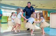  ?? AP- Allyn DiVito ?? In this photo provided by Johns Hopkins All Children’s Hospital, security guard David Dean dances with McKinley Moore, Avalynn Luciano, Lauren Glynn and Chloe Grimes at the hospital in St. Petersburg, Fla., in August 2018. The girls, who were diagnosed with cancer in 2016 and became fast friends while undergoing treatment, reunite every year.