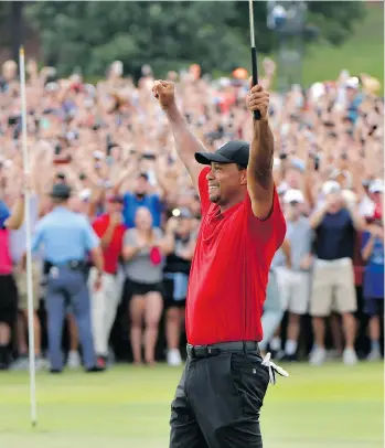  ?? HYOSUB SHIN/THE ASSOCIATED PRESS ?? Tiger Woods celebrates after making his putt for par on the 18th green to win the Tour Championsh­ip on Sunday in Atlanta, his first PGA victory in more than five years.