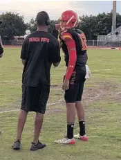  ?? WELLS DUSENBURY/STAFF ?? Deerfield Beach QB Tyron Herring talks to his coach during Thursday’s Chaminade-Madonna game.