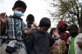  ?? Photograph: Veronica G Gardenas/The Guardian ?? Asylum-seeking children pray in a plaza where some have been living for weeks after being sent back under Title 42 due to the pandemic with their parents in Reynosa, Mexico, on 24 March.