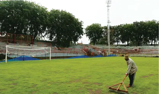  ?? ROBERTUS RISKY/JAWA POS ?? PERBAIKAN JALAN TERUS: Seorang pekerja merawat rumput di Stadion Gelora 10 November kemarin. Tahun depan pemkot memperbaik­i tribun meski Piala Dunia U-20 diundur pada 2023.