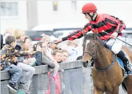  ??  ?? Jockey Aaron Kuru gifts his goggles to an excited child as he brings the Hastings jumper No Change back at Rotorua last Sunday.