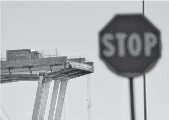  ?? Luca Zennaro / Associated Press ?? A truck hit the brakes as a car passed him, the driver said, saving the vehicle from plunging off the Morandi Bridge in Genoa, northern Italy, which collapsed during a sudden, violent storm.